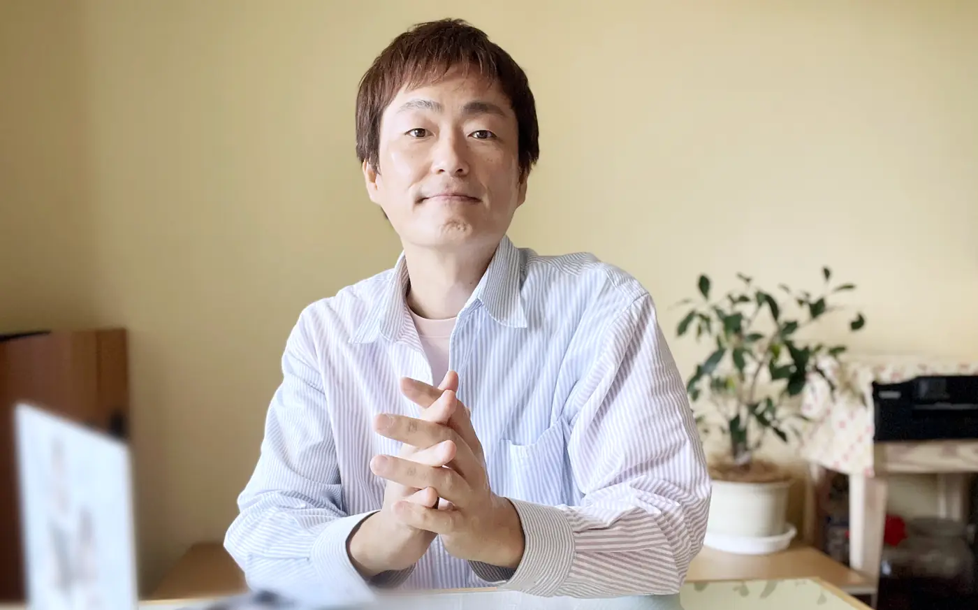 手を組んで、まっすぐこちらを見るコナン(小南邦雄)